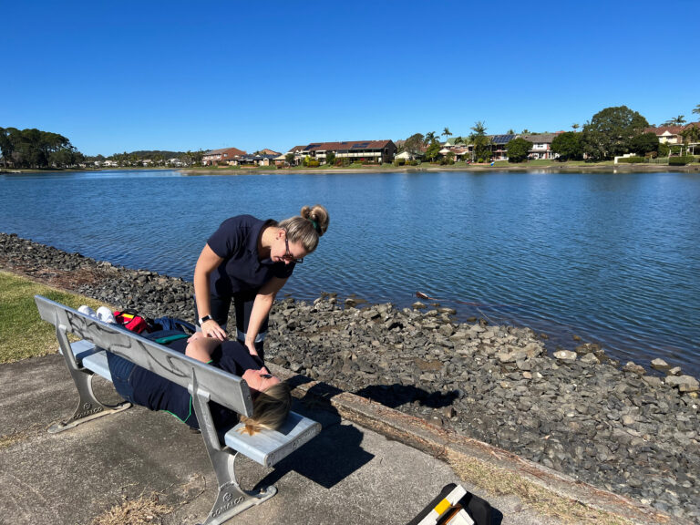 Two HEED Health Education Students practice assessments by a lake/river.